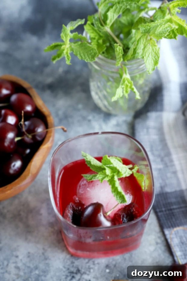 Cherry Bomb Whiskey Smash 3 A perfectly crafted Cherry Whiskey Smash cocktail, garnished with fresh cherries and mint, ready to be enjoyed.