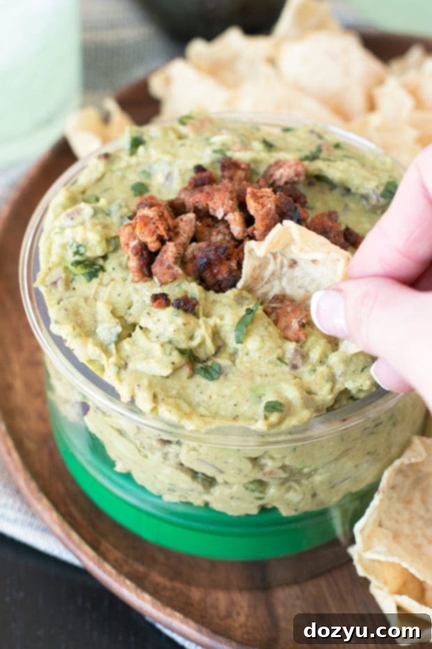 A large bowl of Chipotle Chorizo Guacamole, perfectly mashed and garnished.