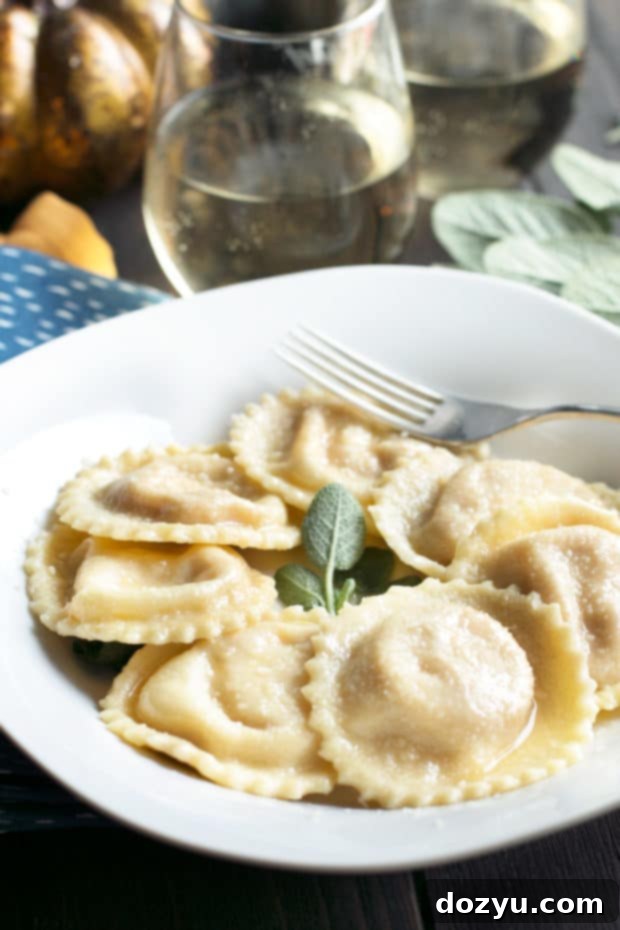 Pumpkin Ricotta Ravioli with Brown Butter Sage Sauce 7 Plated Pumpkin Ricotta Ravioli with Brown Butter Sage Sauce, garnished with fresh sage leaves.