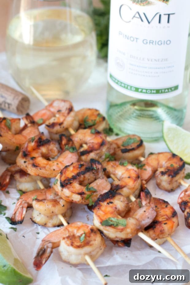 Zesty Mango Garlic Shrimp Skewers with Spicy Cilantro Dip 4 A plate of Mango Garlic Shrimp Skewers with dipping sauce, set on a rustic wooden table, ready to be enjoyed as a summer appetizer. | cakenknife.com #21andup @CavitWines
