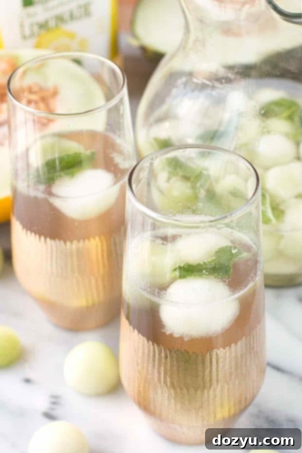 Melon Sangria served in glasses with a pitcher in the background