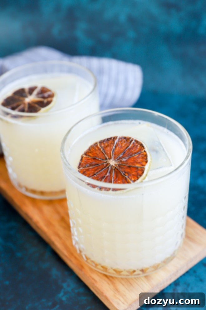 Soju Yogurt Delight 8 Close-up of a Korean distilled spirit drink in a glass with ice and a subtle garnish, highlighting the drink's appealing clarity and texture