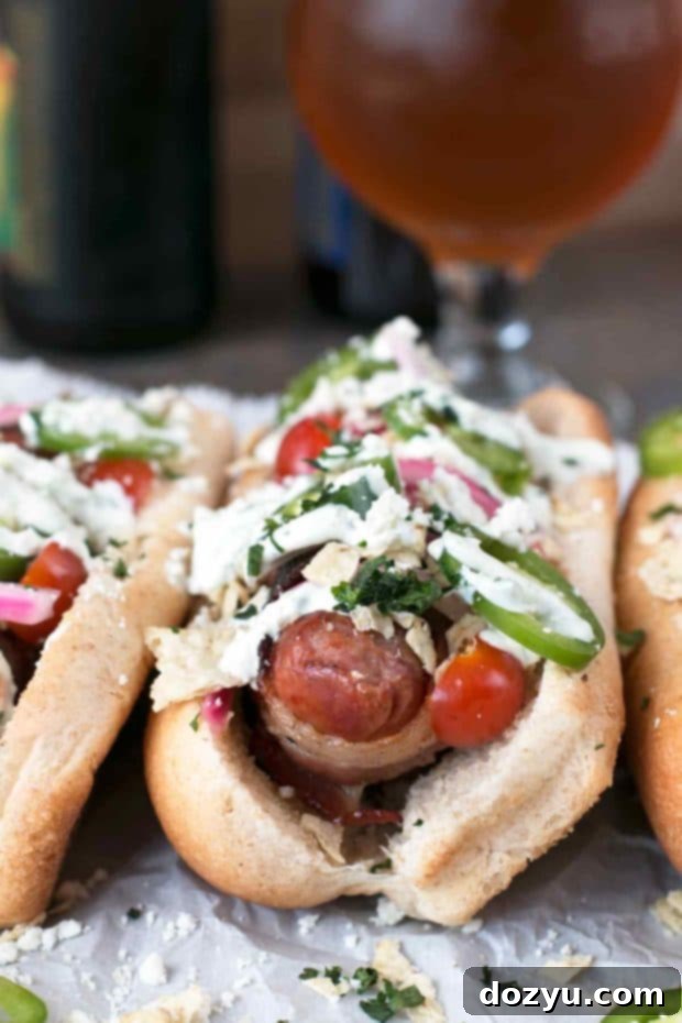 Kickin' Bacon-Wrapped Brats & Zesty Pickled Red Onions 3 Close-up of a loaded Spicy Bacon-Wrapped Bratwurst with Homemade Pickled Red Onions and fresh toppings | cakenknife.com #bratwurst #hotdog #summer #bacon