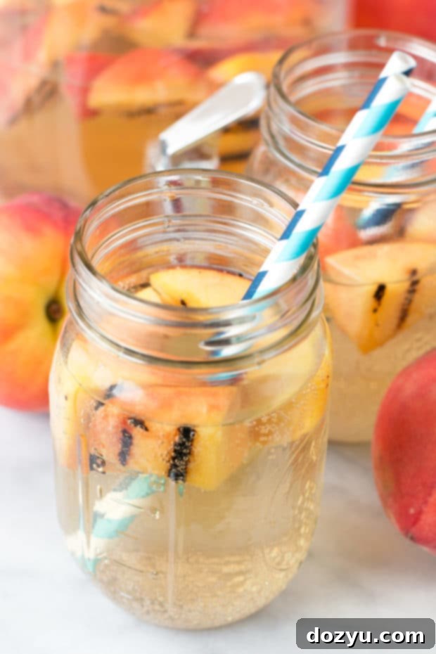Effervescent Grilled Peach Sangria 7 A pitcher of Sparkling Grilled Peach Sangria, garnished with fresh peaches and ready to serve