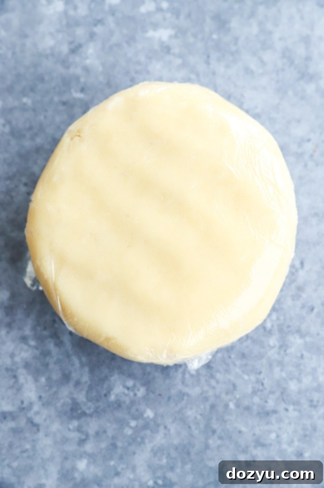 Decadent Milk Chocolate Dipped Shortbread 4 Disk of shortbread cookie dough wrapped tightly in plastic wrap, chilling in the refrigerator.