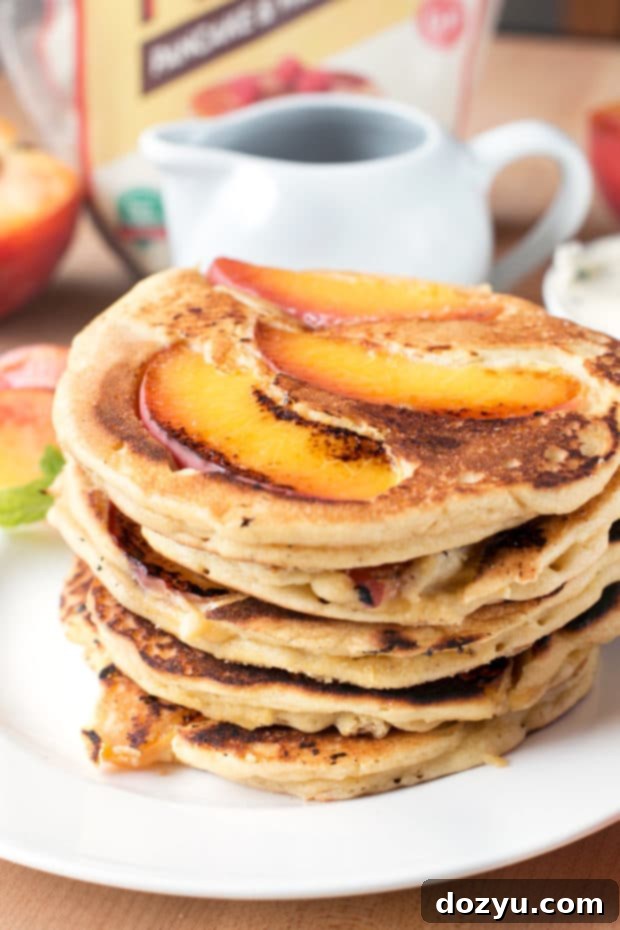 Golden Peach Pancakes with Whipped Mint Butter 5 Close-up of a single peach pancake, showcasing its fluffy texture and perfectly cooked peach slices, highlighting its versatility as a healthy and inclusive breakfast option.