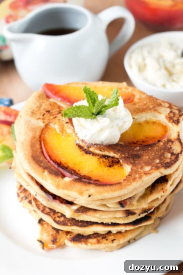 Golden Peach Pancakes with Whipped Mint Butter 9 Variety of peach pancakes on a serving platter, emphasizing their fluffy texture and golden-brown caramelization, ready for any topping choice.