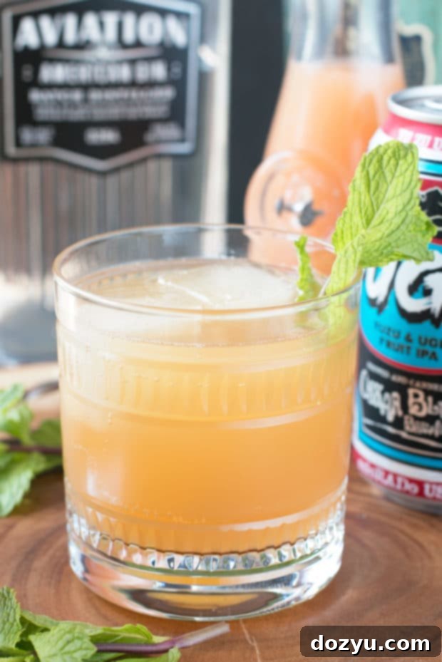 A vibrant Elvis Cocktail, a refreshing grapefruit gin beer cocktail, garnished with a fresh mint sprig, ready to be enjoyed on a sunny day.