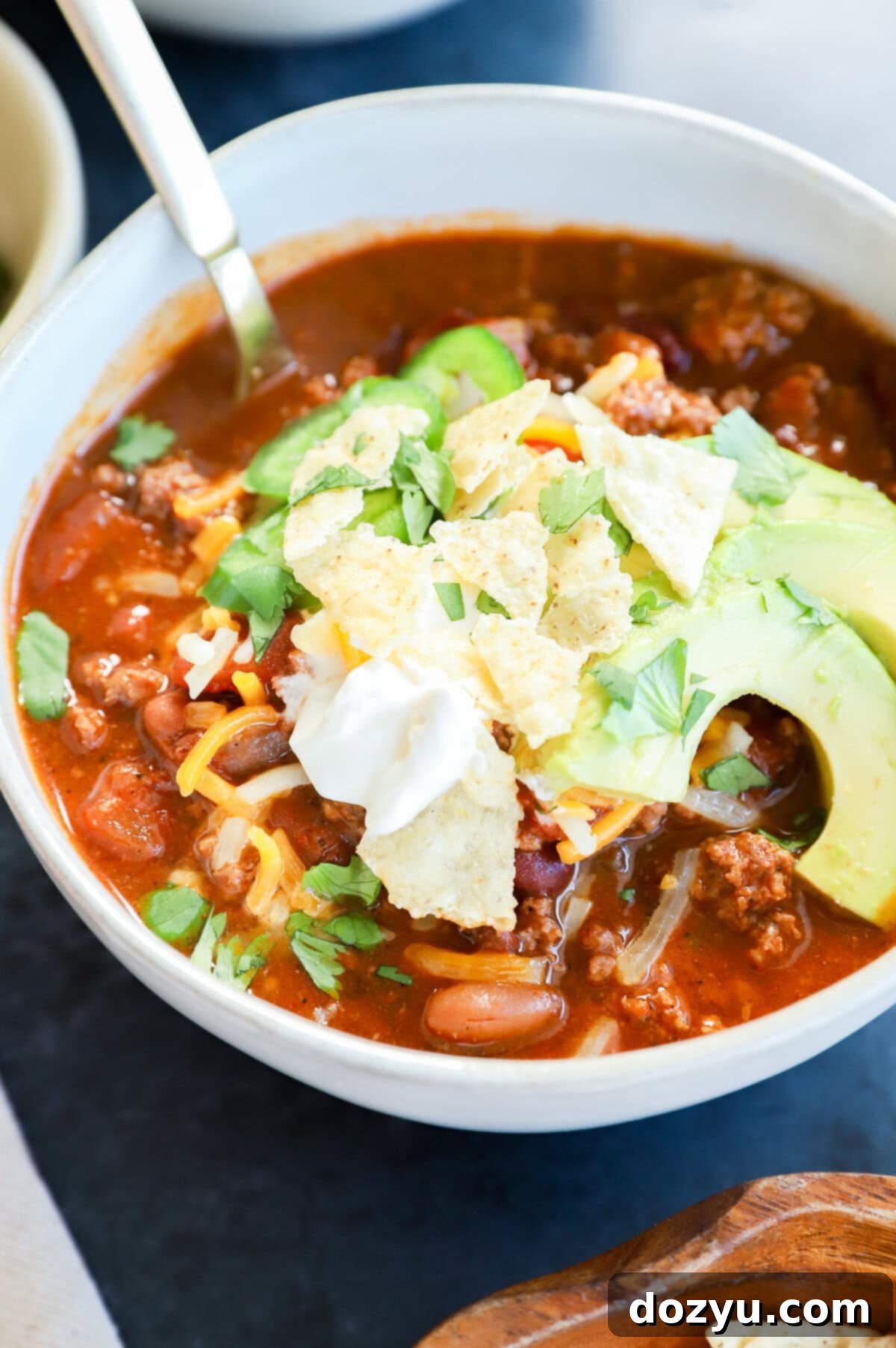 Fiery Taco Chili 9 Spicy taco chili in a bowl with avocado, sour cream, and cheese