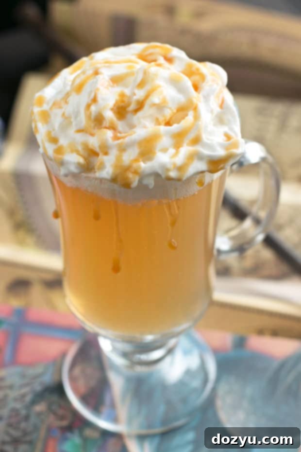 A close-up shot of a creamy Butterbeer Cocktail, showcasing its frothy top and inviting texture. The drink is presented in a clear glass, emphasizing its delightful appearance and making it irresistible for Harry Potter fans.