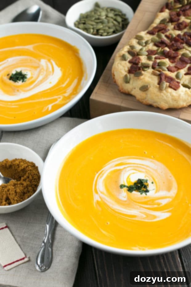 Curried Roasted Butternut Squash Soup with Bacon Pumpkin Seed Bread served on a table