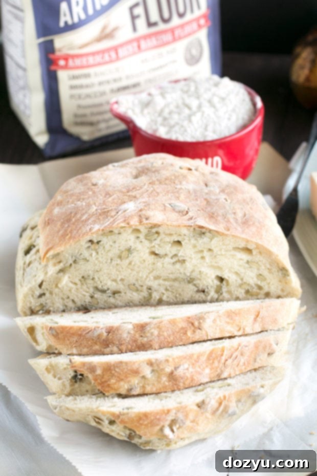 A slice of Harvest Pumpkin Seed Bread with a smattering of pumpkin seeds on top