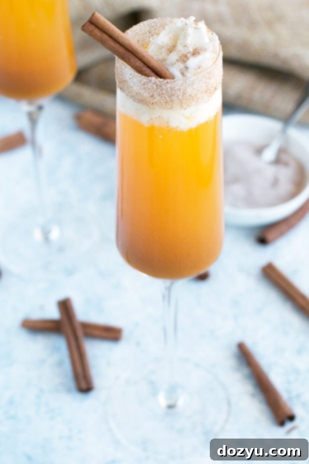 Spiced Pumpkin Mimosa 5 Ingredients for a Pumpkin Pie Mimosa laid out on a table, including pumpkin puree, pumpkin spice, sugar, and a bottle of champagne.