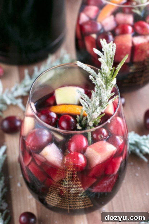 Ingredients laid out for Red Christmas Single Serve Sangria: red wine, orange juice, brandy, fruit, and cinnamon sticks. Keywords: sangria ingredients, red wine recipe, holiday cocktail prep.