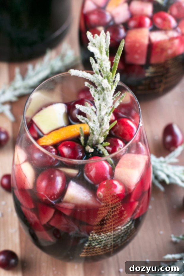 Red Christmas Single Serve Sangria | A refreshing and festive individual serving of sangria, perfect for holiday gatherings. Garnished with rosemary for a special touch.
