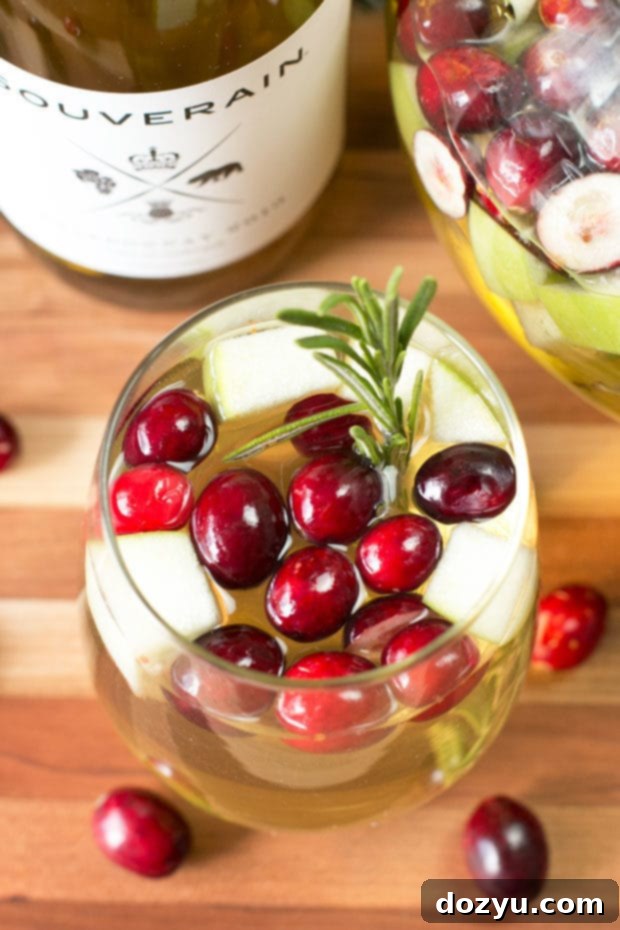 Christmas Sangria | A festive Christmas Sangria with cranberries, green apple, and rosemary, perfect for holiday parties.