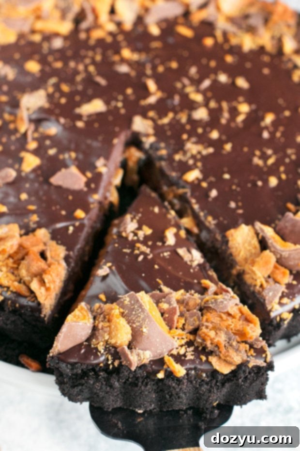 Two slices of Easy Butterfinger Caramel Ganache Tart with beer in the background