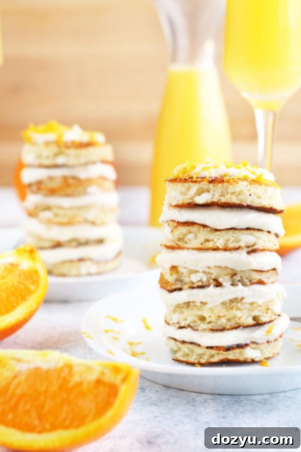 Mimosa Pancake Stacks served alongside glasses of mimosa cocktail