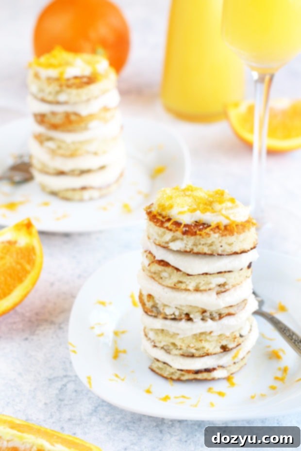 A stack of Mimosa Pancakes with frosting and sprinkles