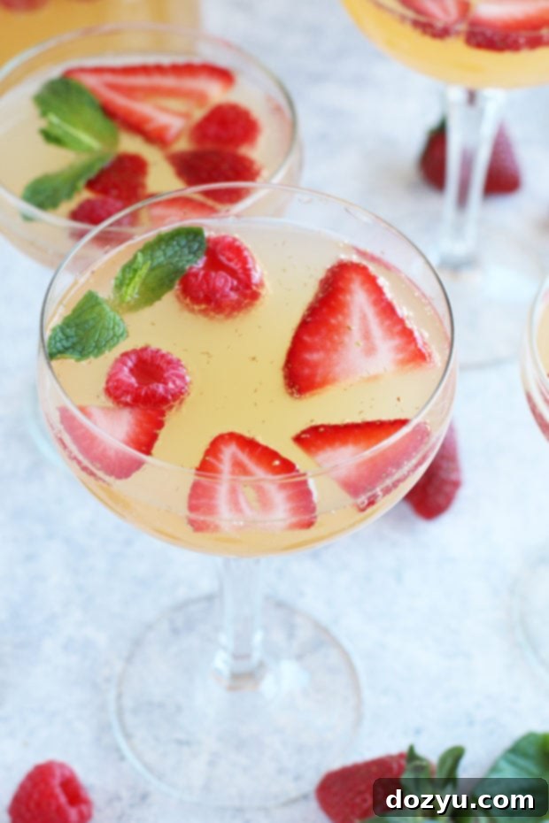 Effortless Bubbly Berry Sangria 8 Easy sangria punch with sparkling wine, berries, and mint in a pitcher and glasses.