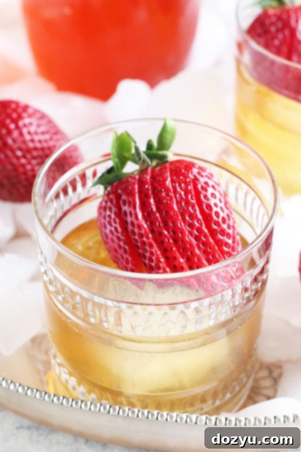 Strawberry Rhubarb Old Fashioned cocktail in a crystal glass with strawberries