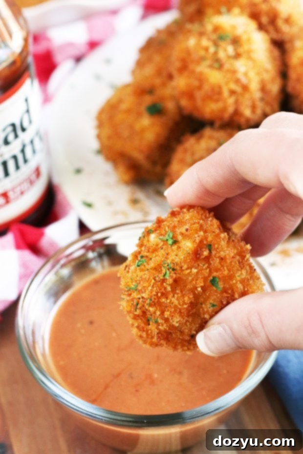BBQ Fried Mac & Cheese Balls 3 Close-up of a single BBQ Fried Mac N Cheese Ball, showcasing its crispy coating and inviting golden color.