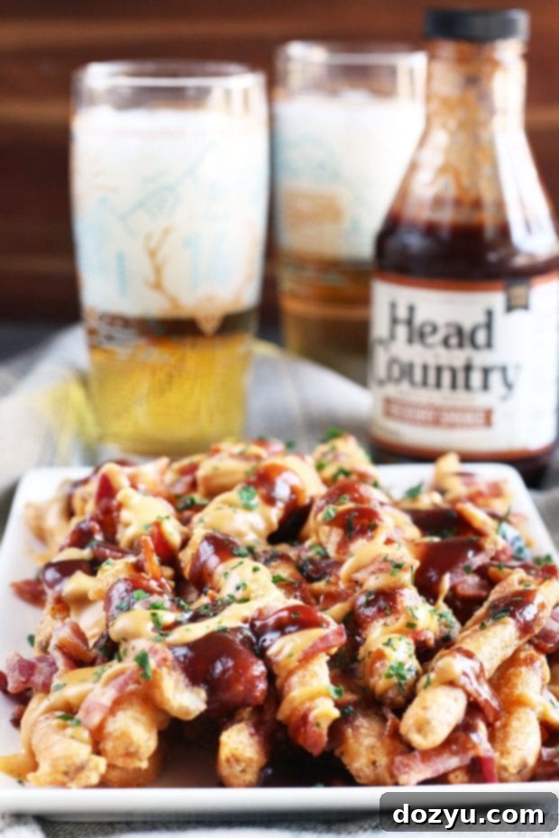 Addictive BBQ Bacon Fries 2 BBQ Bacon Crack Fries piled high with melted cheese and crispy bacon bits, drizzled with BBQ sauce, ready for game day
