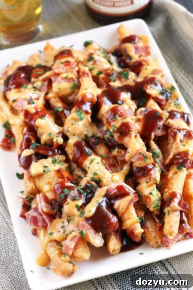 Addictive BBQ Bacon Fries 9 A person reaching for a BBQ Bacon Crack Fry from a large serving platter