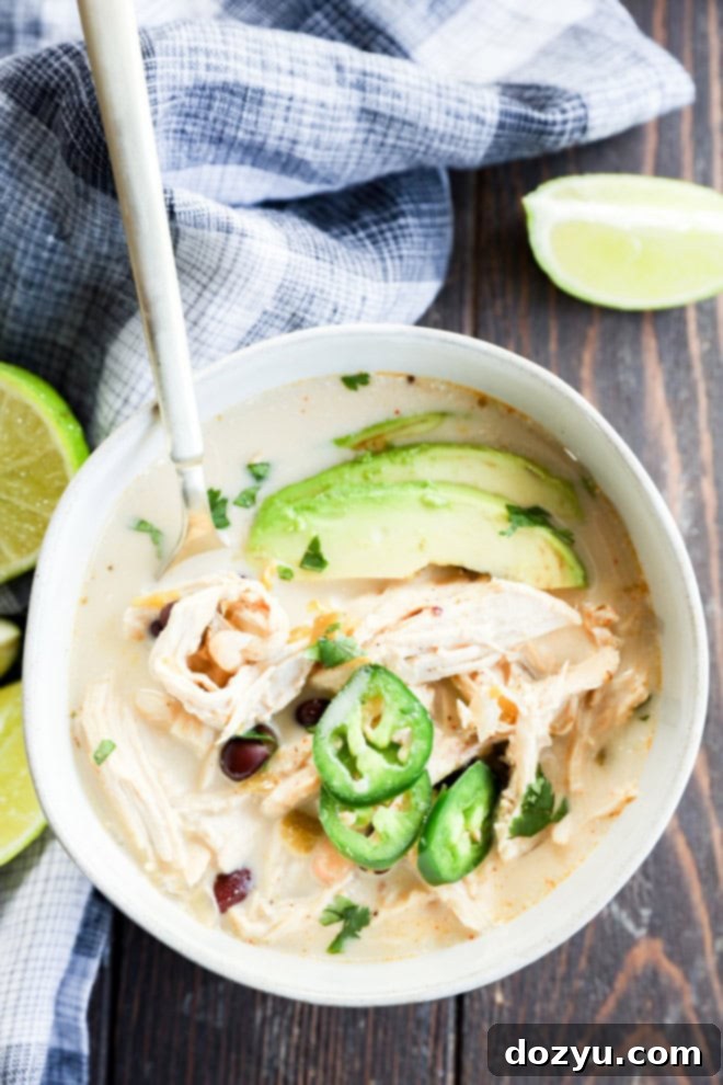 Velvety Slow Cooker White Chicken Chili 9 Bowl of Slow cooker creamy white chicken chili with spoon in it