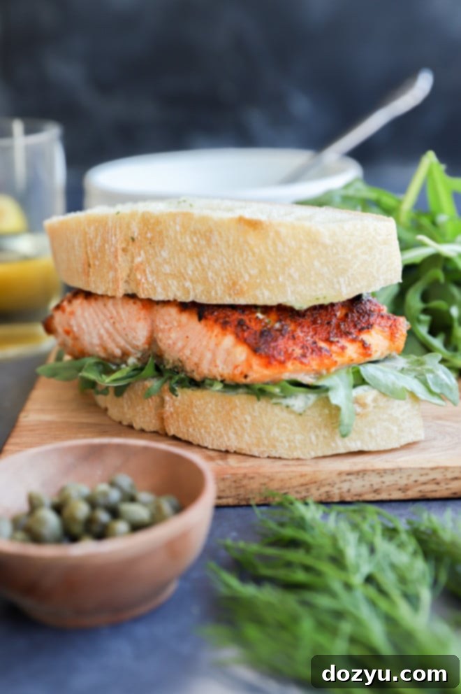 Elevated Salmon Sandwich with Herbed Dill Cream 2 Delicious salmon sandwich on a platter with a side salad