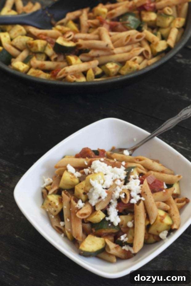 A top-down view of the delicious Ratatouille Skillet with pasta and goat cheese, garnished with fresh basil.