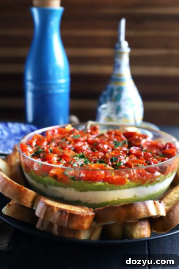 Avocado Ricotta Tomato Pesto Layer Dip served with toasted bread