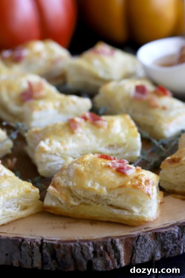 Golden Brie & Bacon Bites 2 Golden, flaky Bite-Sized Baked Bacon Brie Pockets on a platter, ready to serve