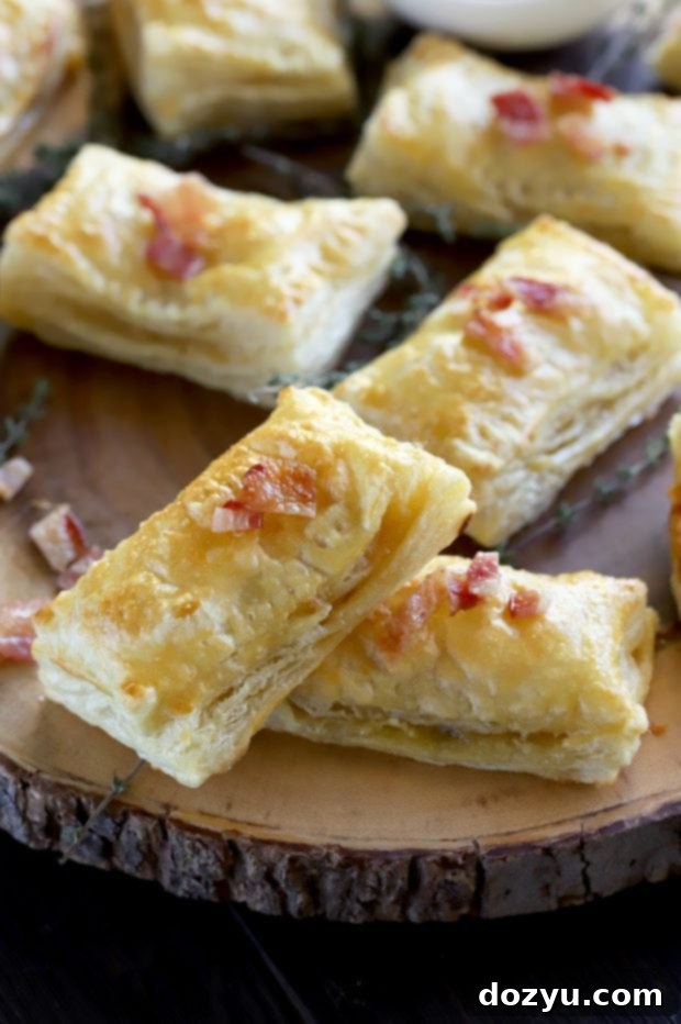 Golden Brie & Bacon Bites 9 A beautifully arranged plate of Bite-Sized Baked Bacon Brie Pockets, garnished with fresh thyme and a drizzle of honey