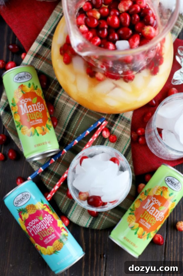 A festive pitcher filled with Spiced Tropical Holiday Champagne Punch, ready to be served at a gathering.