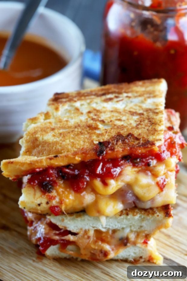Irresistible Inverted French Baguette Grilled Cheese with Chunky Tomato Jalapeño Jam served on a cutting board