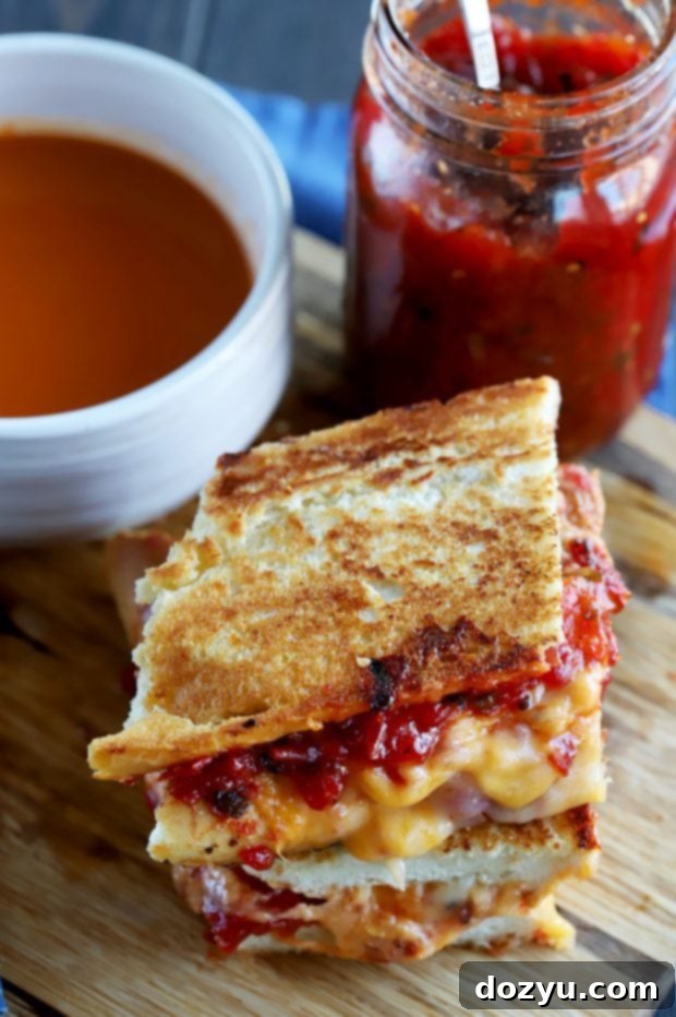 Layering sharp cheddar and Monterey Jack cheese over the tomato jalapeño jam on an inverted baguette