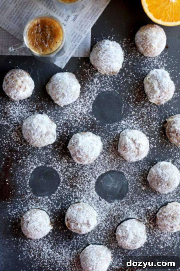 Orange Mocha Snowball Cookies 8 Mocha Orange Mexican Wedding Cookies displayed on a rustic wooden board.