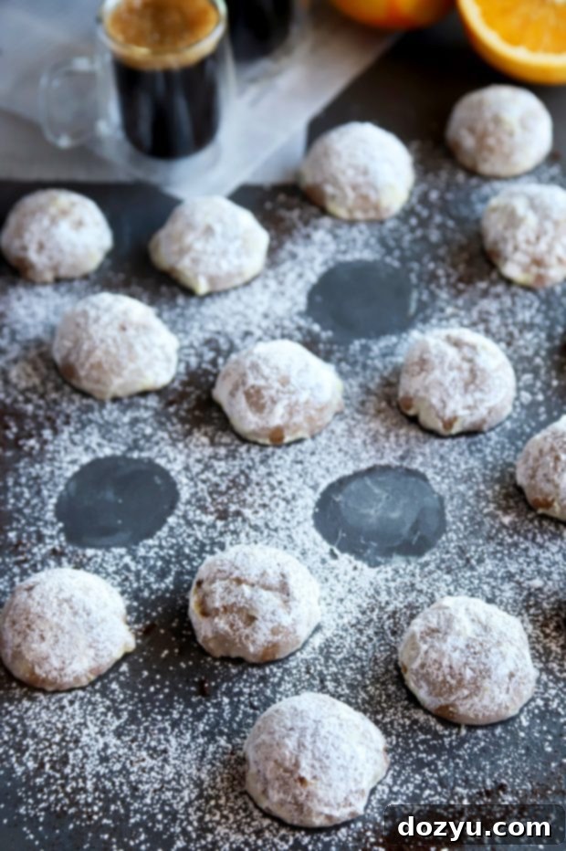 Orange Mocha Snowball Cookies 10 A stack of Mocha Orange Mexican Wedding Cookies dusted with powdered sugar, ready to be enjoyed.