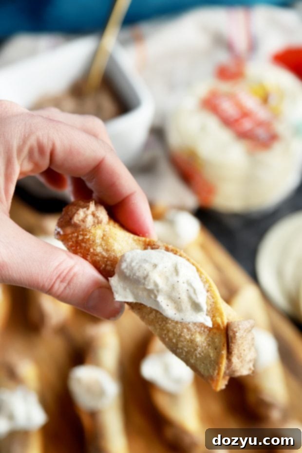 Churro Cheesecake Taquitos – a close-up of the creamy filling being piped into a fried tortilla.