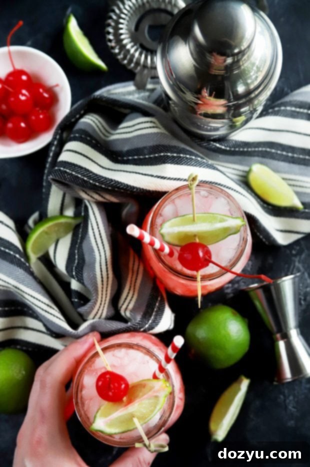 Scarlet Zest Elixir 10 Homemade vodka cherry limeade with lime wedge and maraschino cherry