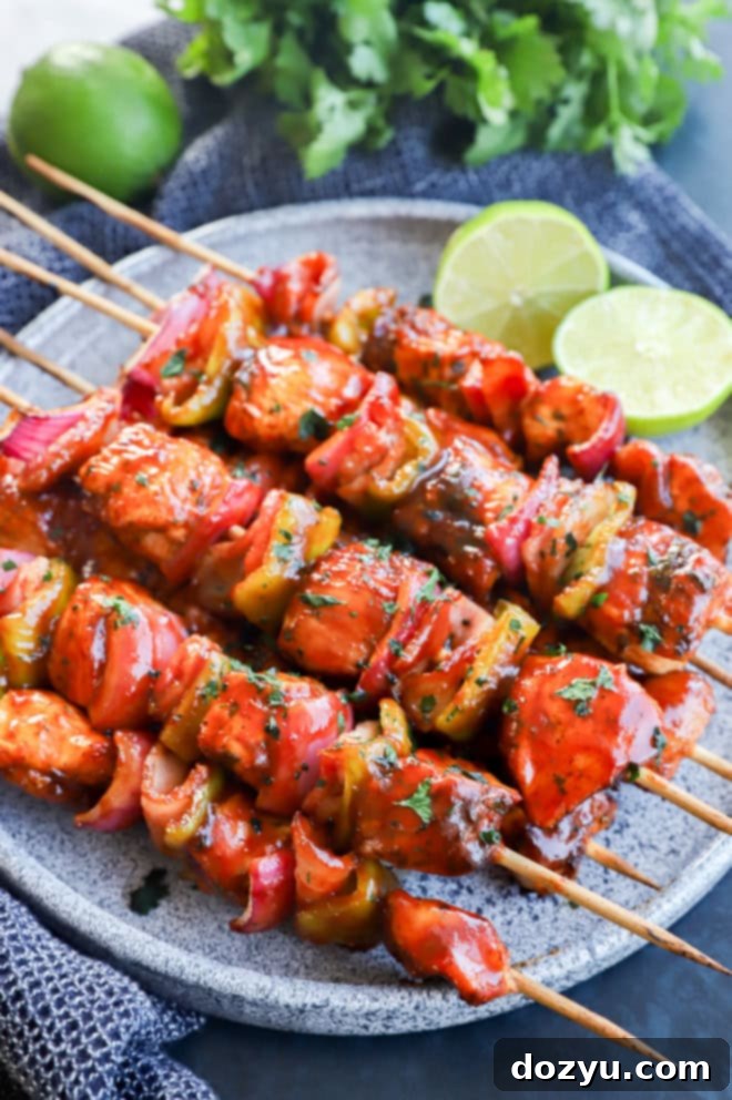 Smoky Chipotle Grilled Chicken Skewers 6 Lime halves with chicken kabobs brushed with barbecue sauce