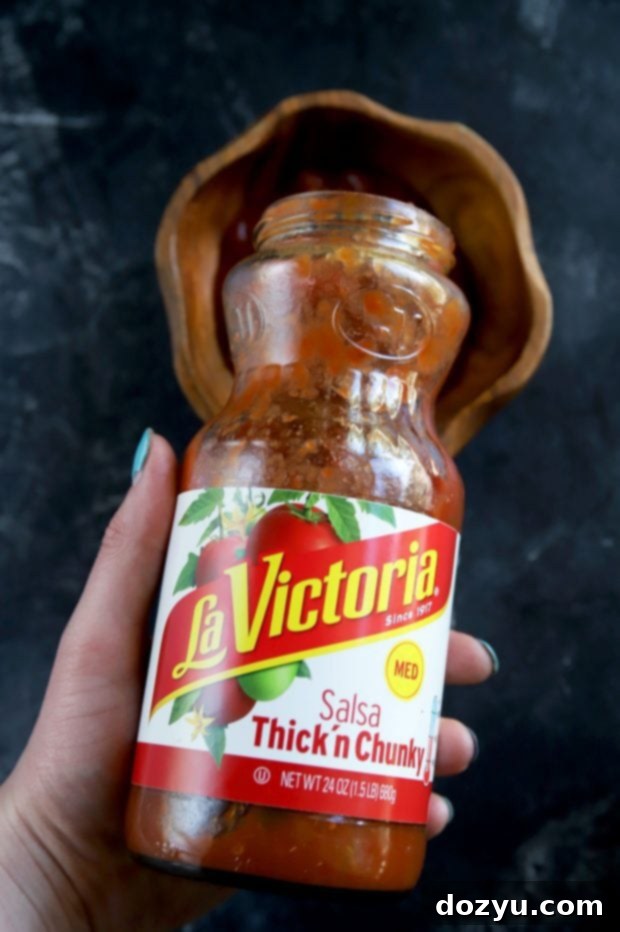 Poblano-Infused Chicken Enchilada Empanadas 10 A bottle of LA VICTORIA® Salsa Thick’n Chunky being poured, highlighting its rich texture and quality, ready to be used in a recipe or as a dip.