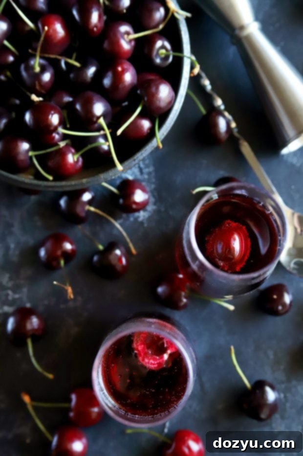 Overhead shot showcasing fresh cherries, a jigger, champagne glasses, and completed mimosa cocktails