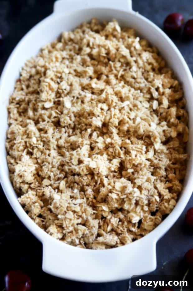 Sweet & Boozy Bourbon Cherry Peach Crumble 6 crumble topping in a baking dish before baking