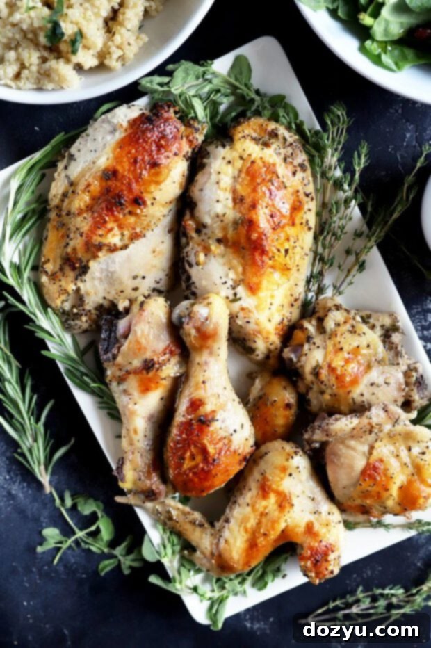 Aromatic White Wine and Herb Roasted Chicken 4 Roasted chicken on a white plate with fresh herbs