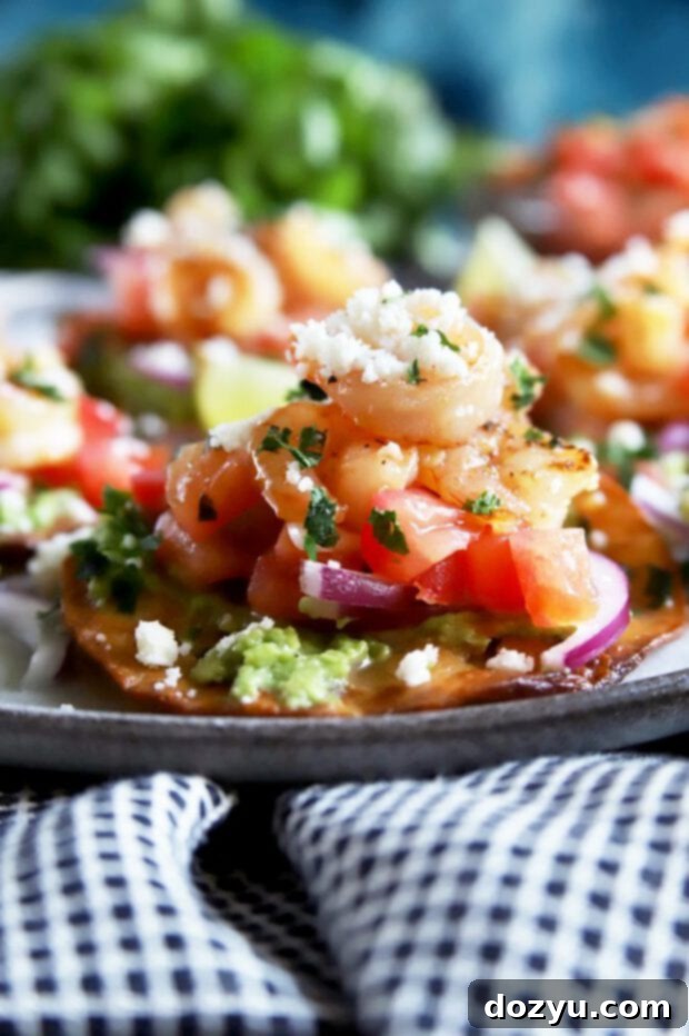 Side perspective of multiple shrimp tostadas stacked on a plate