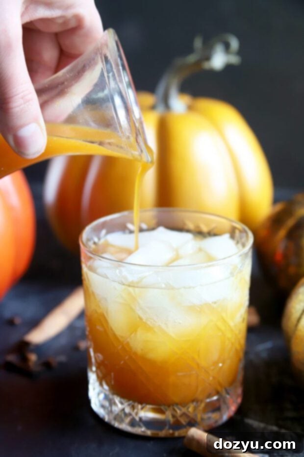 The Perfect Pumpkin Spice Syrup 9 Pouring simple syrup into a pumpkin cocktail