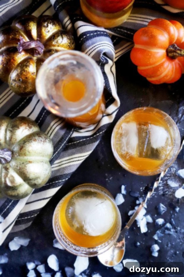 Autumn Ember Old Fashioned 7 Top-down shot of two Pumpkin Spice Bourbon Old Fashioned cocktails on a wooden surface with fall decorations