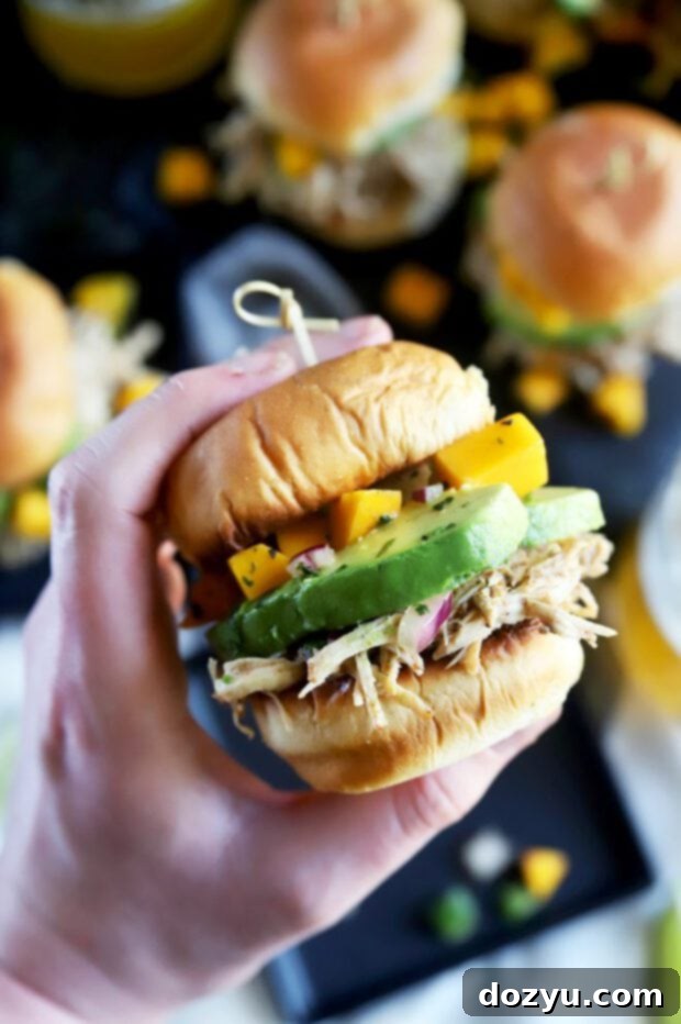 Tropical Jerk Chicken Sliders with Zesty Mango Salsa 4 Hand holding a jerk chicken slider